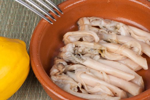 Fresh raw razor clams served in lemon marinade
