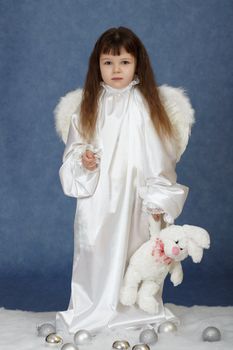 Little girl dressed as an angel with a rabbit on a blue background