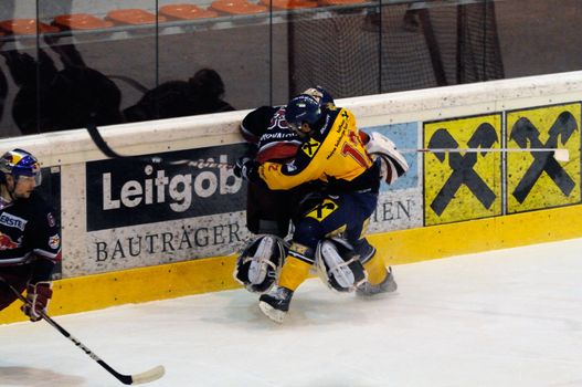 ZELL AM SEE, AUSTRIA - DECEMBER 7: Austrian National League. Putnik charging Salzburg Goalie Konovalov. Game EK Zell am See vs. Red Bulls Salzburg (Result 4-6) on December 7, 2010, at hockey rink of Zell am See