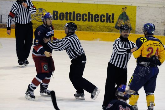 ZELL AM SEE, AUSTRIA - DECEMBER 7: Austrian National League. Referees stopping fight between Schernthaner and Mitterdorfer. Game EK Zell am See vs. Red Bulls Salzburg (Result 4-6) on December 7, 2010, at hockey rink of Zell am See