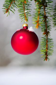 red bauble christmas ball ornament outside in a snowy winter scene