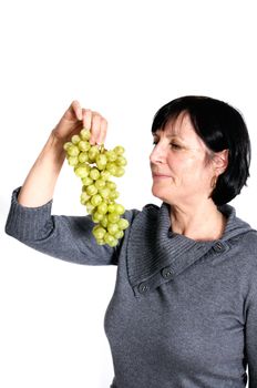 Aged woman with bunch of fresh grapes isolated on white background