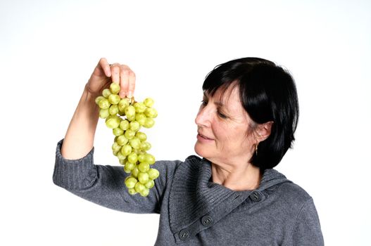 Aged woman with bunch of fresh grapes isolated on white background