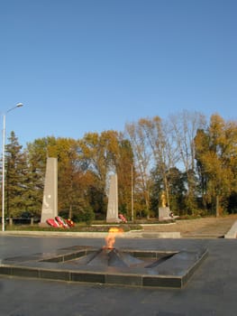 Monument; eternal flame; laid; architectral building; styles; park; garden