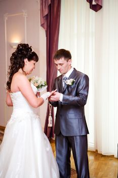 Bride and Groom Exchanging rings focus on groom