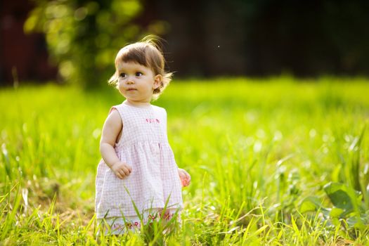 One year little girl walking in summer park outdoors