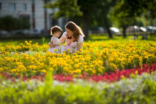 Happy mother walking with daughter in park outdoors