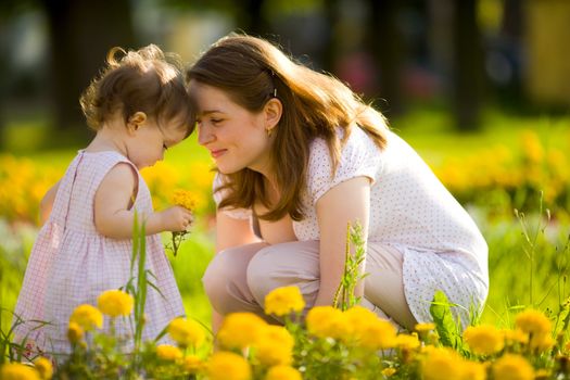 Happy mother walking with daughter in park outdoors