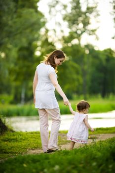Happy mother walking with daughter in park outdoors