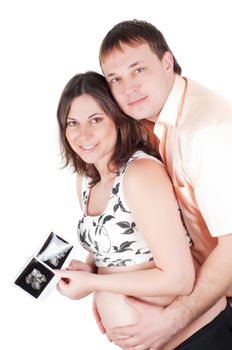 Happy young couple holding a sonogram of their child