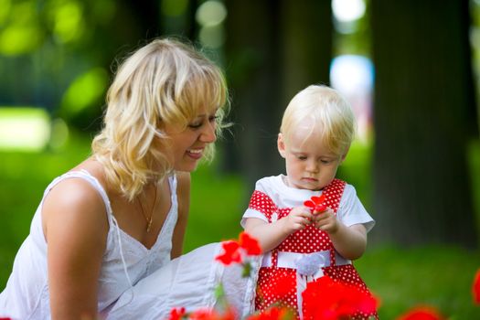 Happy mother walking with daughter in park outdoors