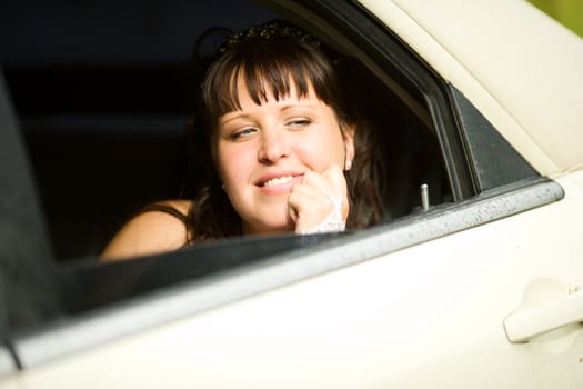 Bride sitting in car before wedding begins thoughtful look