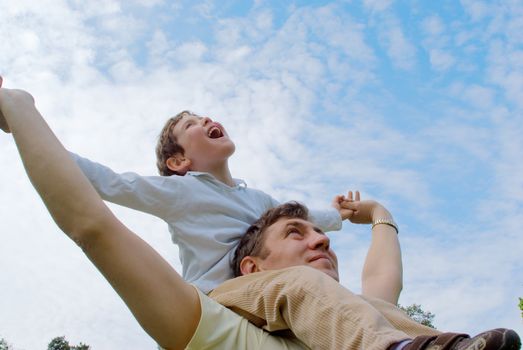 Father and his son against the blue sky