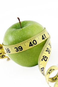 Green apple with yellow measure tape