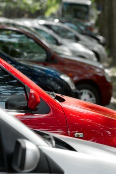 Row of parking cars, selective focus on the red one