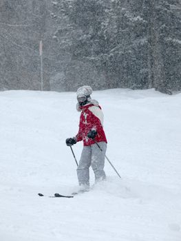Female skier in heavy snowfall