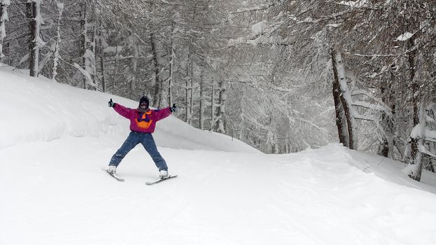 Happy female skier coming through the forest