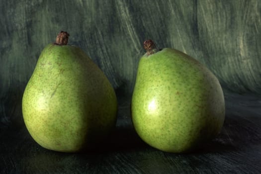 Two green pears isolated on painted background