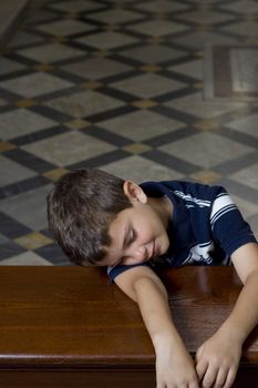 A small boy sleeps over a church pulpit