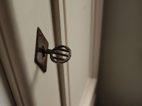 Old metal key in a diamond shaped wordrobe lock