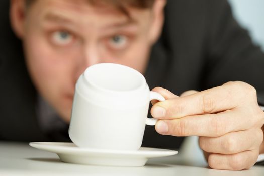 Young businessman makes predictions using coffee grounds - close up