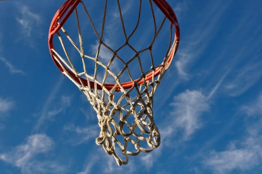 Basketball Hoop with Blue Sky and White Clouds