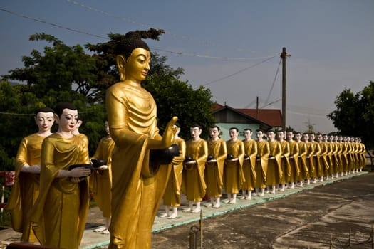 Statue of Buddha and disciples are alms round in temple myanmar