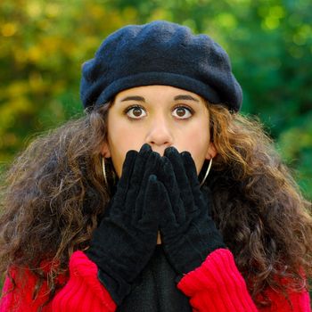 Surprised / scared girl covering her mouth with her hands, eyes wide open