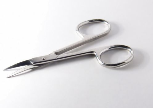 Small metal manicure scissors on a white background