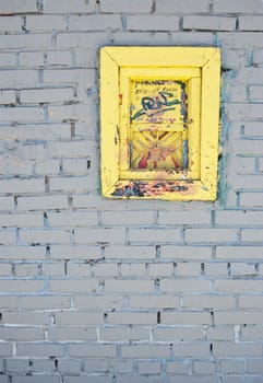 White brick wall with a yellow old window