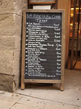 Hand written menu stand on a street corner in Barcelona