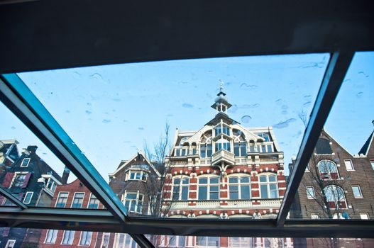 Typical old Amsterdam houses - view through the window of a canal boat