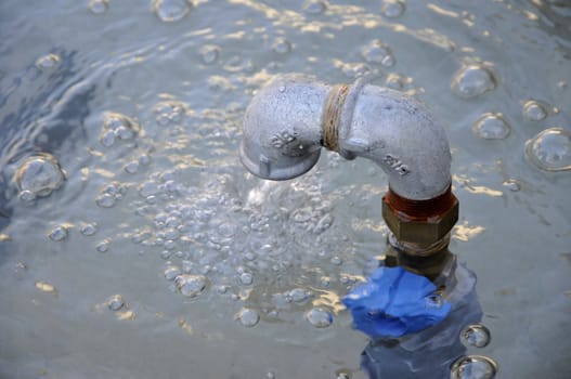 Close-up of a metallic tube with water that flow