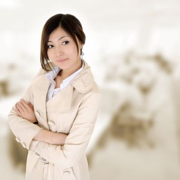 Confident business woman with coat thinking in office.