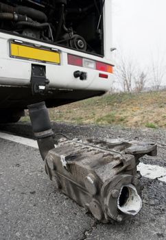 Broken down bus with an engine part fallen out