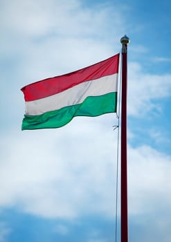 Hungarian national flag waving against bright sky