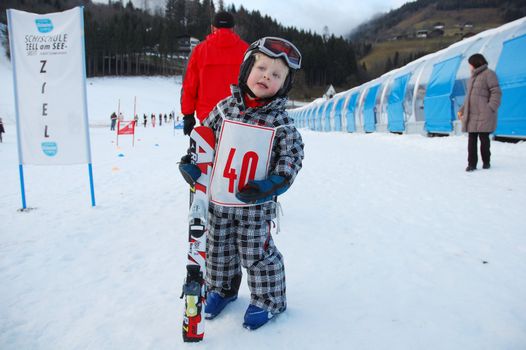 ZELL AM SEE, AUSTRIA - DECEMBER 22: Three year old girl after race at Ski school in Zell am See, Austria. Austrian ski schools are famous for the training plans, that guarantees the safety of about 10 million ski drivers on austrian ski areas per year.