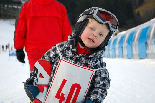 ZELL AM SEE, AUSTRIA - DECEMBER 22: Three year old girl after race at Ski school in Zell am See, Austria. Austrian ski schools are famous for the training plans, that guarantees the safety of about 10 million ski drivers on austrian ski areas per year.