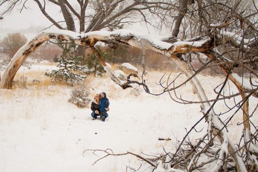 A mother and son sitting underneath a tree.