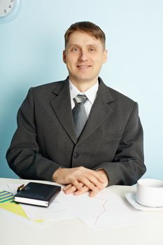 Smug businessman sitting in an office at the table