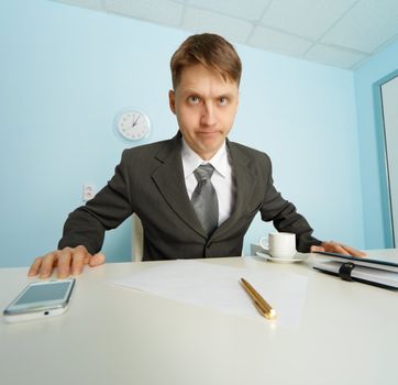 Angry boss looks at the slave sitting at the table