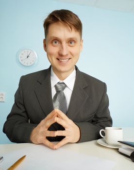 Happy clerk sitting at his desk with a smile