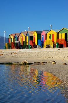 Brightly painted wooden bathing huts at St James Beach, near Cape Town, South Africa.