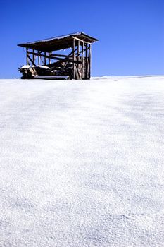 Winter scene in mountains. Old house and snow