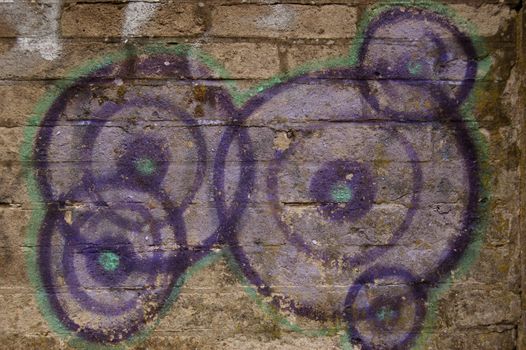 Purple circles graffiti on old brick wall. 