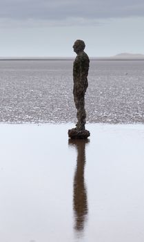 CROSBY BEACH, ENGLAND - SEPTEMBER 24: Statues forming Another Place by Antony Gormley on Crosby Beach on September 24, 2011. The statues are slowly rusting away with the tides and wind.