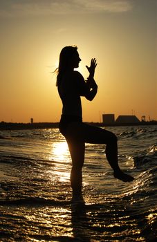 Beautiful girl practising Tai Chi on a beach.