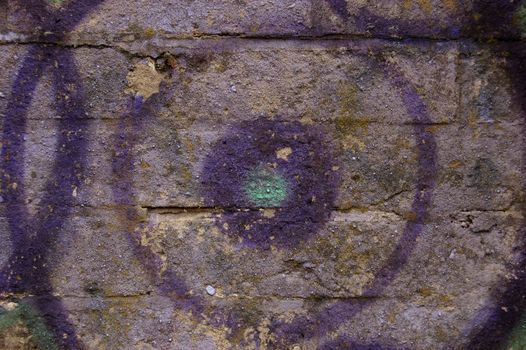 Purple circles graffiti on old brick wall. 