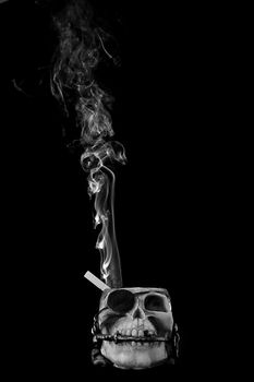 smoking kills concept. Cigarette in skull ashtray.