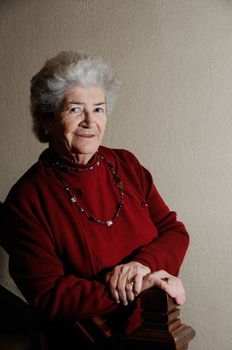 Shot of old senior lady with red clothes smiling and posing